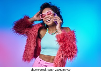 Excited African woman in trendy clothes talking on mobile phone against colorful background - Powered by Shutterstock