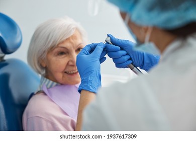 Excited Aged Woman Watching Doctor Changing Dental Drill