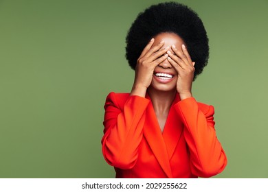 Excited Amazed African Woman Cover Eyes Emotional From Pleasant Surprise Business Victory Or Lottery Win. Elegant Afro American Businesswoman In Red Suit Overjoyed With Good News, Isolated Studio Shot