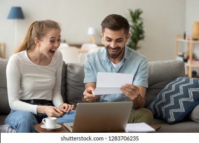 Excited Amazed Happy Couple Winners Screaming With Joy Rejoicing Reading Good News Holding Mail Paper Letter Celebrating Taxes Refund, Cheap Great Offer, Economy Promotion In Bank Statement At Home