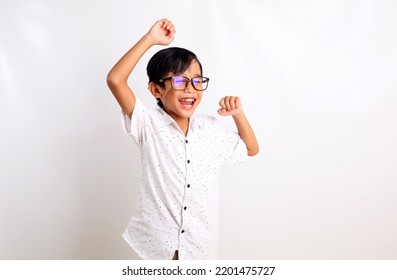 Excited Asian Boy Standing While Showing Celebrate Gesture. Isolated On White Background With Copyspace