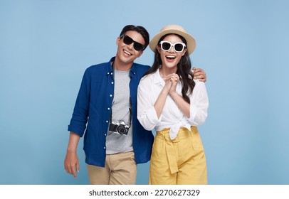 Excited Asian couple tourist dressed in summer clothes to travel on holidays isolated on blue background. - Shutterstock ID 2270627329