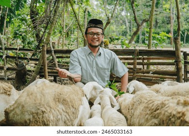 Excited Asian Muslim man giving out grass to feed the goats in livestock farm for sacrifices. Eid Al Adha concept. - Powered by Shutterstock