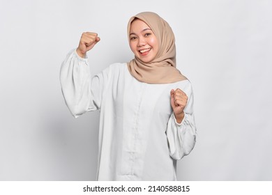 Excited Asian Muslim woman celebrating victory isolated over white background - Powered by Shutterstock