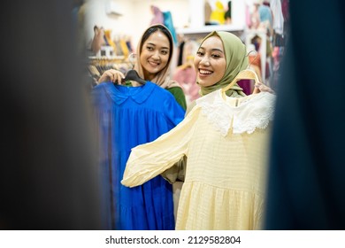 Excited Asian Muslim Woman Trying New Clothes