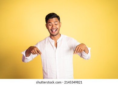 excited asian young man with two fingers pointing down