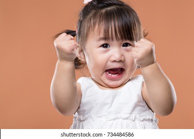 Excited baby girl holding arm fist