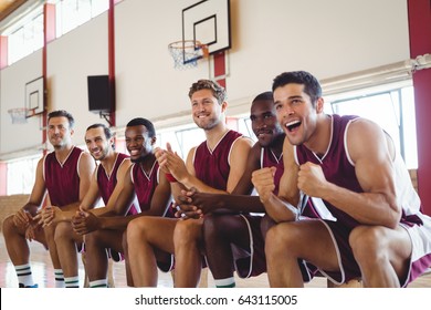 Excited basketball player sitting on bench in court - Powered by Shutterstock