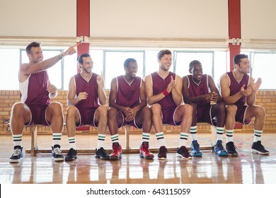 Excited Basketball Player Sitting On Bench In Court