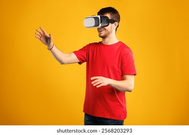 Excited bearded guy using VR headset and experiencing virtual reality, isolated on blue studio wall
