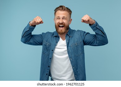 Excited bearded hipster blonde man in jeans shirt celebrate success over blue background. - Shutterstock ID 1962701125