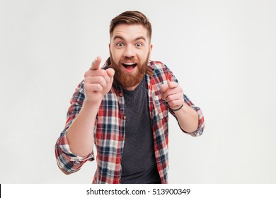 Excited Bearded Man In Checkered Shirt Pointing Fingers At Camera Isolated On A White Background