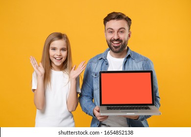 Excited Bearded Man Have Fun With Child Baby Girl. Father Little Kid Daughter Isolated On Yellow Background. Love Family Day Parenthood Childhood Concept. Hold Laptop Computer With Blank Empty Screen