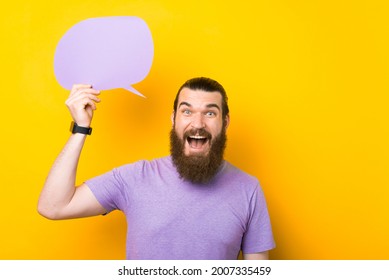 Excited bearded man holding speech bubble with empty space for text on yellow background - Shutterstock ID 2007335459