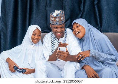 Excited beautiful family seated together making use of a mobile phone, wireless technology, family togetherness - Powered by Shutterstock