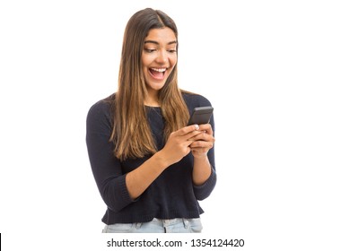 Excited Beautiful Woman Receiving SMS In Mobile Phone Over Plain Background