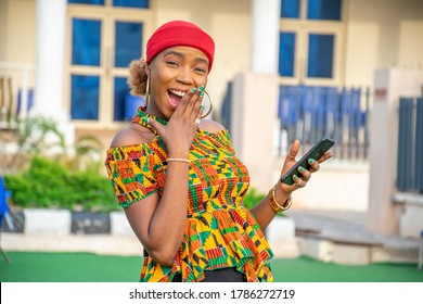 Excited Beautiful Young African Lady Holding Her Phone