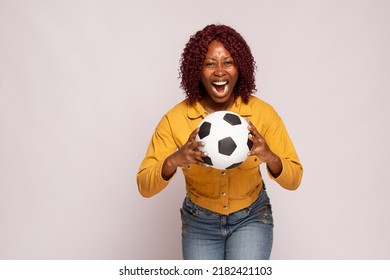 Excited Black Lady Holding A Football Shows Her Passion