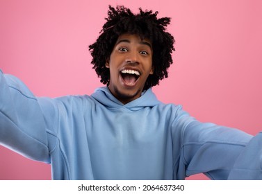 Excited Black Teen Guy Taking Selfie On Pink Studio Background. Self-portrait Of Funky African American Teenager Making Mobile Photo Of Himself, Smiling At Camera, Having Fun