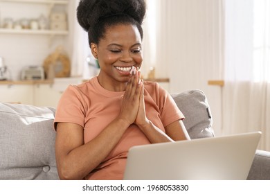 Excited Black Woman Look At Laptop Screen Happy To Good News, Laughing African Girl Reading Email Or Message In Social Network, Win Online Lottery, Surprised With Business Victory, Sit On Sofa At Home