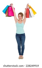 Excited blonde holding up shopping bags on white background