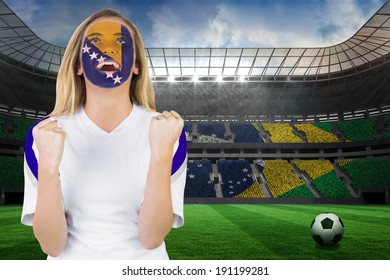 Excited Bosnia Fan In Face Paint Cheering Against Large Football Stadium With Brasilian Fans