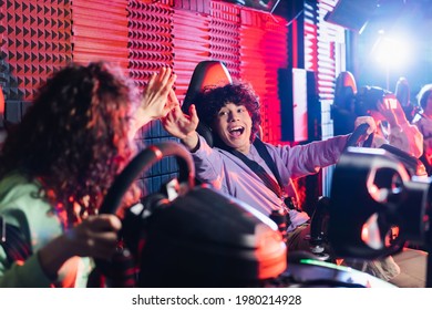 excited boy giving high five to african american girl in car racing simulator - Powered by Shutterstock