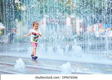 excited boy running between water flow in city park - Shutterstock ID 199676546