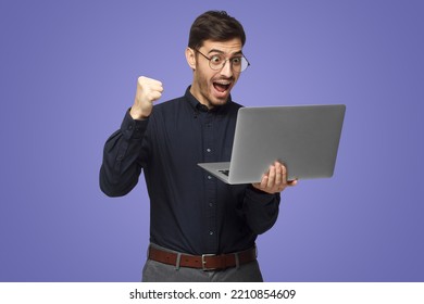 Excited Business Man Looking At Laptop Screen With Mouth Wide Open, Celebrating His Win, Isolated On Purple Background