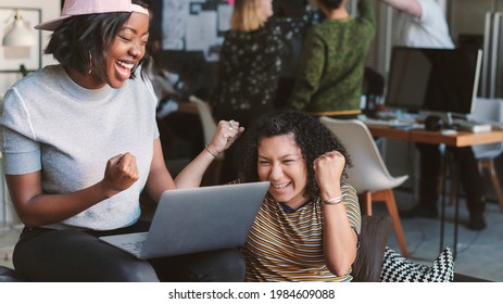 Excited Business People Looking At A Laptop Screen