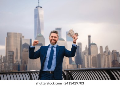 Excited Businessman hold dollar banknote over New York City. Dollar notes concept. Credit and loan in USA. American finance. Businessman hold hundred dollar banknotes outdoor. Celebrating the success.