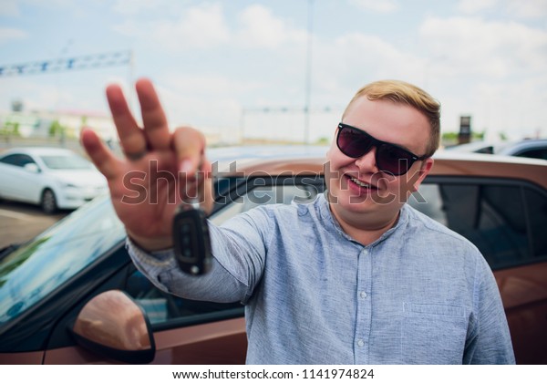 Excited\
Businessman Sitting In Car Showing New Car\
Key