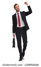 Excited Businessman Walking Forward On White Background And Celebrating While Looking Up To Side And Holding Suitcase, Full Body Picture