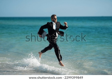 Excited businessman in wet suit run in sea. Funny business man, crazy comic business concept. Remote online working. Crazy summer business. Fun business lifestyle. Funny freelance businessman.