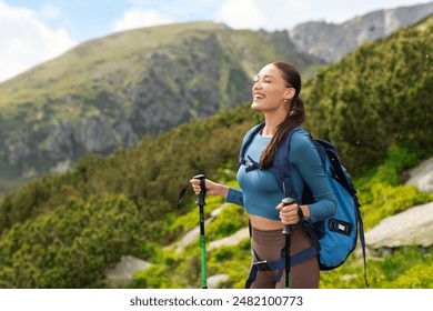 Excited carefree woman with backpack and hiking equipment standing against the backdrop of mountain scenery. Travel, vacation and active lifestyle - Powered by Shutterstock