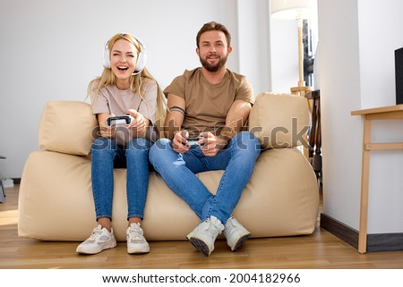 Excited caucasian couple playing video games with television in new apartment. excited and funny for amazing experience in new video game at lving room. Relax and hobby concept. Side view, copy space