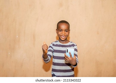 Excited Caucasian Ginger African Black Boy Holding A Phone And Looking At Camera On A Gray Studio Wall