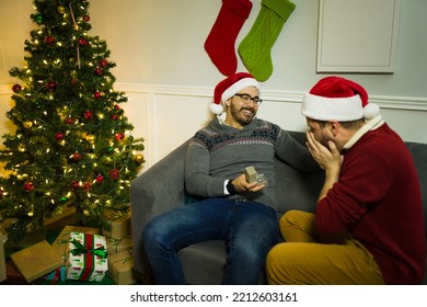 Excited Caucasian Man Surprising His Gay Partner With An Engagement Ring During The Christmas Holidays