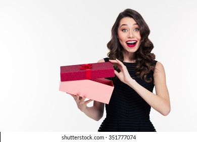 Excited Cheerful Attractive Young Woman With Retro Hairstyle In Black Dress Opening Gift Over White Background