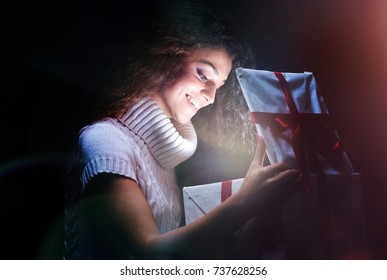 Excited Cheerful Attractive Young Woman Opening Gift Over Black 