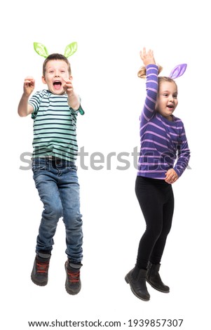 Excited cheerful jumping kids boy and girl in Easter bunny ears hat action. Full body isolated on white background
