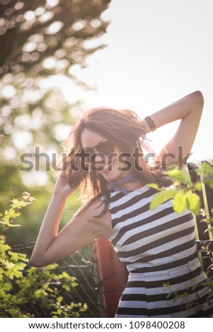 Excited, cheerful young woman enjoying a wonderful day in nature, jumping around, running and feeling extremely happy