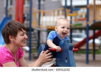 Excited Child With His Mother At The Outdoor Playground