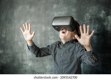 Excited Child In Virtual Reality Glasses Isolated On Black Background. School Education Program For Children. Surprised Little Kid Boy Looking In VR Glasses.