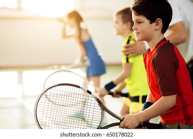 Excited children playing tennis on court