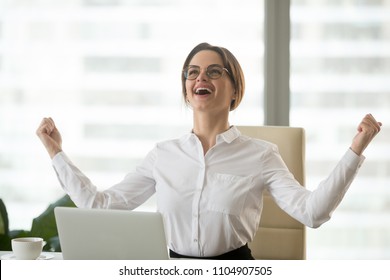 Excited confident businesswoman winner celebrating victory enjoying business success, online result or professional achievement feeling happy powerful being promoted or got new great opportunity