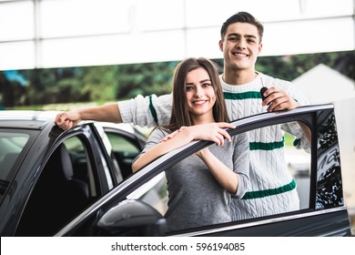 Excited Couple Buying A Car At The Dealer