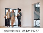 Excited couple entering in a new house while meeting with their real estate agent. Copy space.