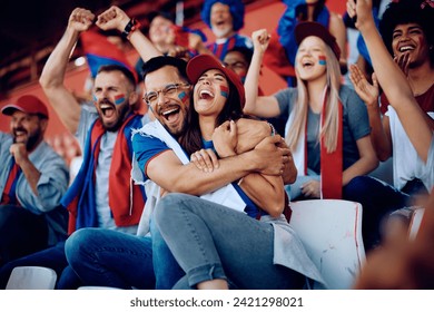 Excited couple of fans embracing after their favorite team's championship victory at the stadium. - Powered by Shutterstock