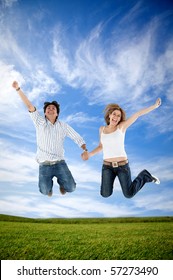 Excited couple holding hands and jumping outdoors